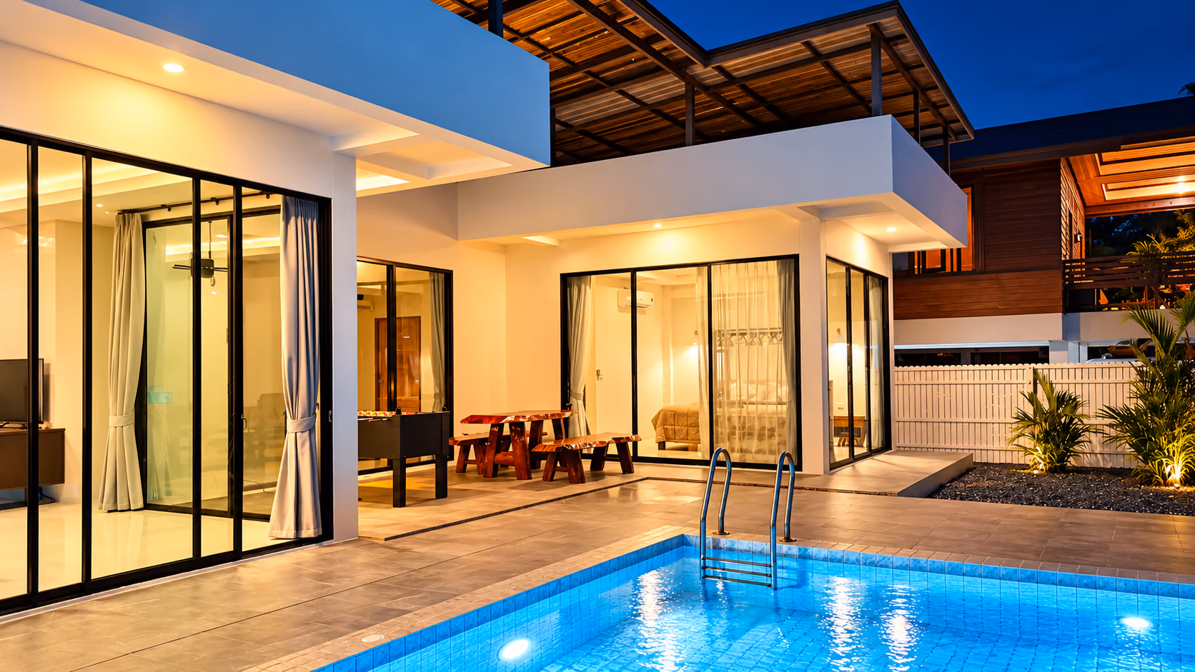 The villa at dusk, with the illuminated plunge pool and covered terrace